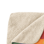 Rainbow camo sherpa blanket folded with one corner turned back, showing the multicolor printed front and textured beige sherpa backing.