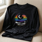Close-up of black long sleeve tee showing the rainbow wave, crescent moon, shoreline, and palm tree chest graphic.
