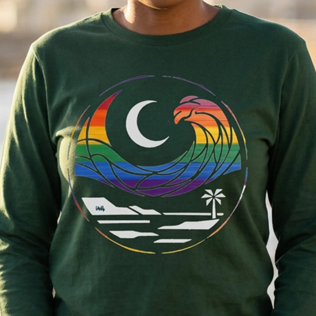  Close-up of a person wearing a forest green long sleeve tee with a rainbow wave, white crescent moon, shoreline, and palm tree graphic.