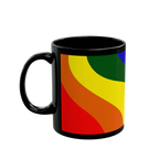 A right side view of the black FREEBRD rainbow wave ceramic mug showing bold rainbow wave design in red orange yellow green and blue.