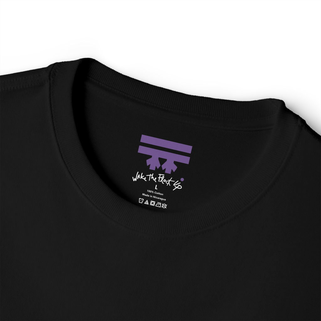 Black T-shirt inner neck print with a purple FREEBRD logo and white handwritten text reading 'wake the flock up'.