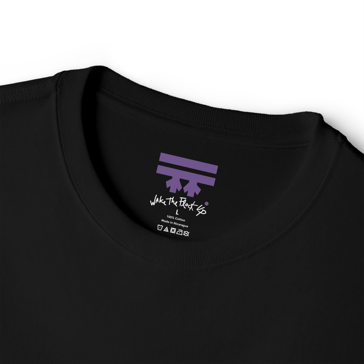 Black T-shirt inner neck print with a purple FREEBRD logo and white handwritten text reading 'wake the flock up'.