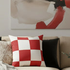 Red and white checkered faux suede pillow layered on a beige sofa with bold abstract wall art, lifestyle.