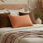 Roman Earth lumbar accent pillow styled on a bed in a modern bedroom.
