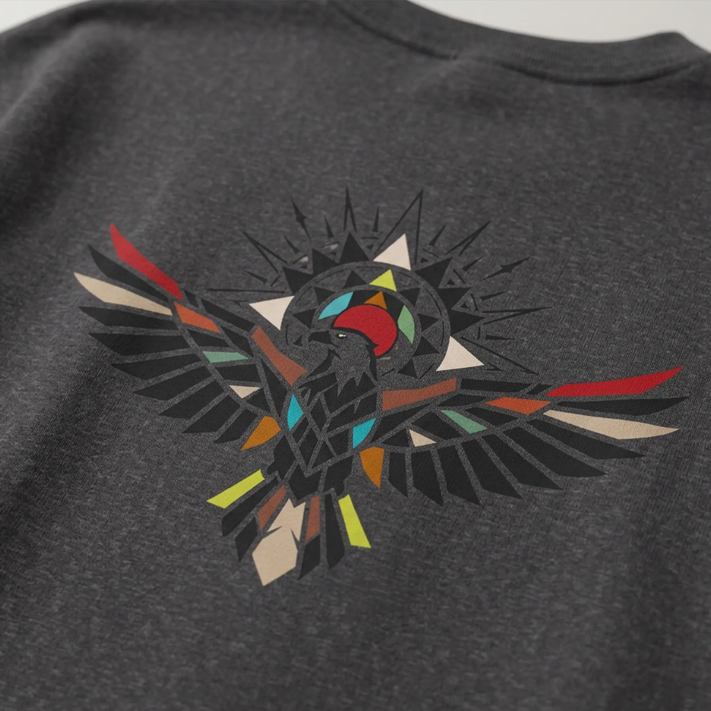 Close-up of a dark grey heather sweatshirt showing the geometric bird graphic with outstretched wings and multicolored accents.