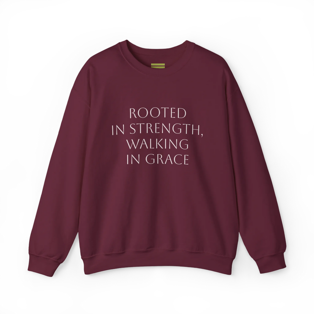 Maroon crewneck sweatshirt with light-colored 'Rooted in strength, walking in grace' lettering across the chest, front flat lay.