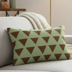 Sage chocolate triangle pattern lumbar pillow styled on a couch in a modern living room.