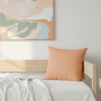 Sandy peach faux suede throw pillow on a minimalist day bed with abstract wall art, lifestyle view.