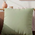 Schist Green faux suede pillowcase styled on a couch in a modern living room.
