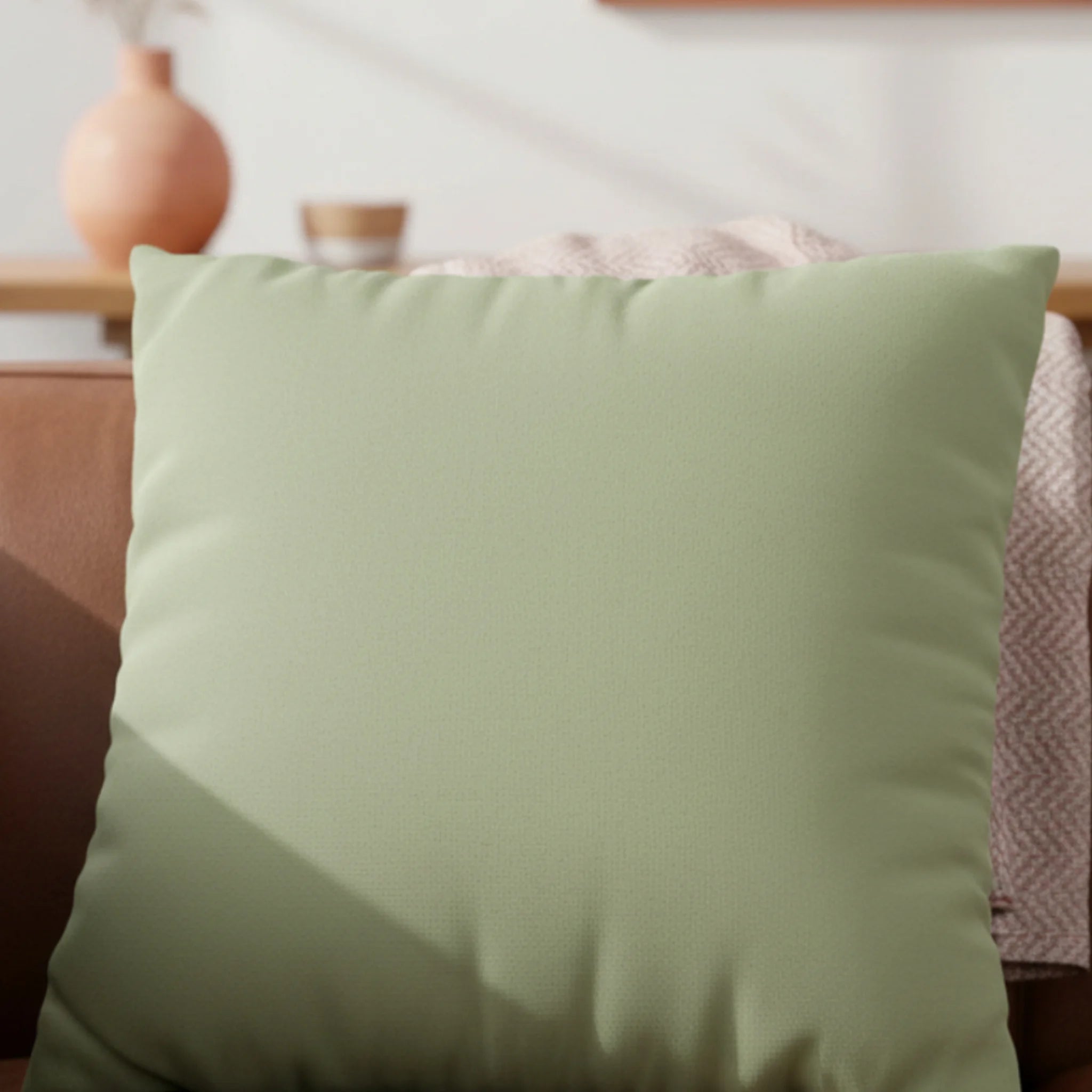 Schist Green faux suede pillowcase styled on a couch in a modern living room.