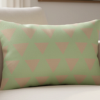 Schist Green triangle lumbar pillow styled on a couch in a modern living room.