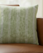 Cognac brown leather sofa in a warm natural light living room styled with the Schist Green Stripe Woven Pillow.