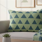 Schist green teal geometric triangle lumbar pillow styled on a couch in a modern living room. 