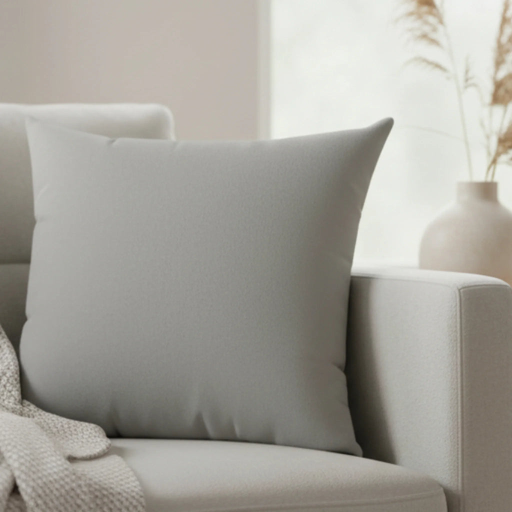 Stardust grey faux suede pillow styled on sofa, soft grey neutral home decor.