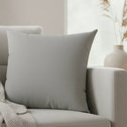 Stardust grey faux suede pillow styled on sofa, soft grey neutral home decor.