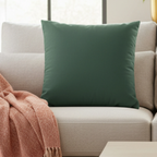 Stromboli Green faux suede pillow styled on a couch in a modern living room.