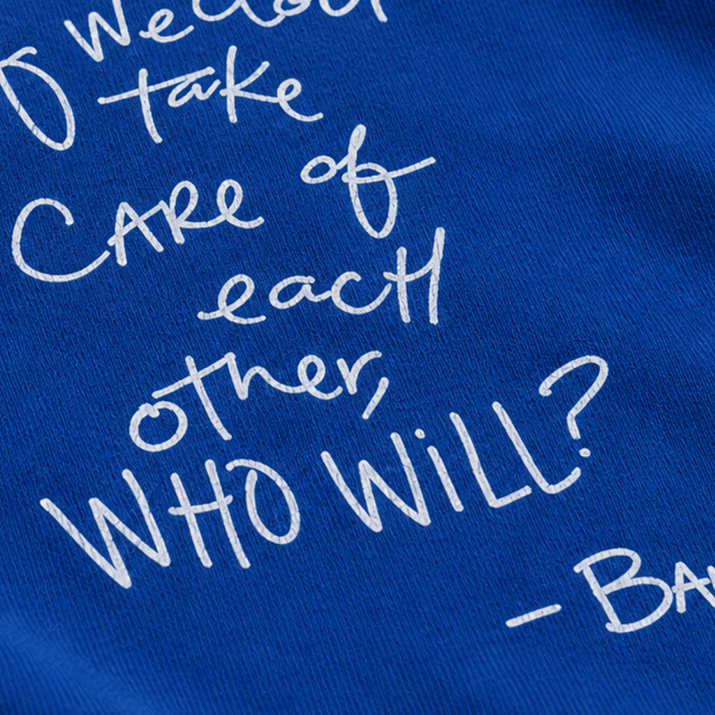 Close-up of partial white handwritten quote artwork on royal blue long-sleeve fabric.