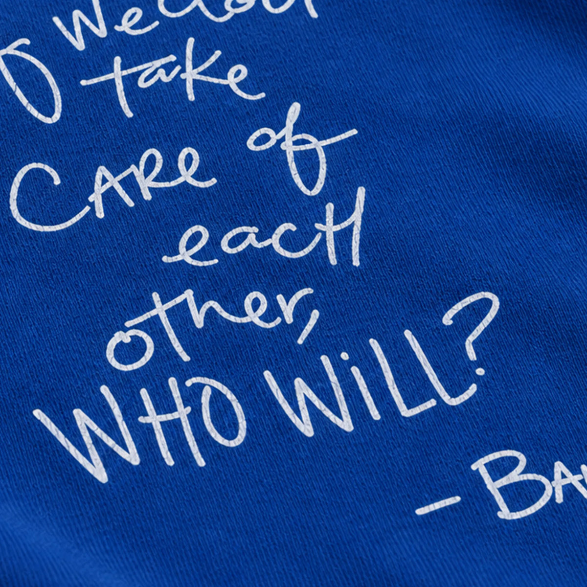 Close-up of partial white handwritten quote artwork on royal blue long-sleeve fabric.