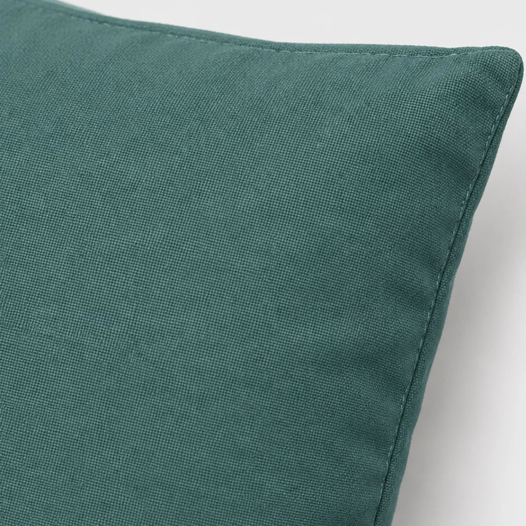 Close-up of the Teal Grey pillow cover showing its muted teal woven surface and stitched edge.