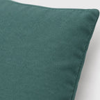 Close-up of the Teal Grey pillow cover showing its muted teal woven surface and stitched edge.