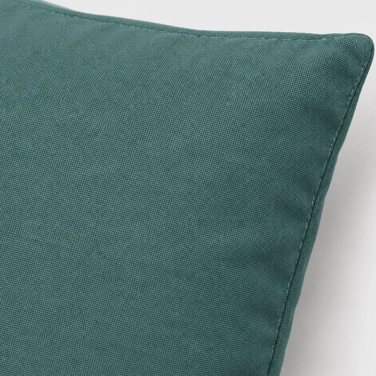 Close-up of the Teal Grey pillow cover showing its muted teal woven surface and stitched edge.