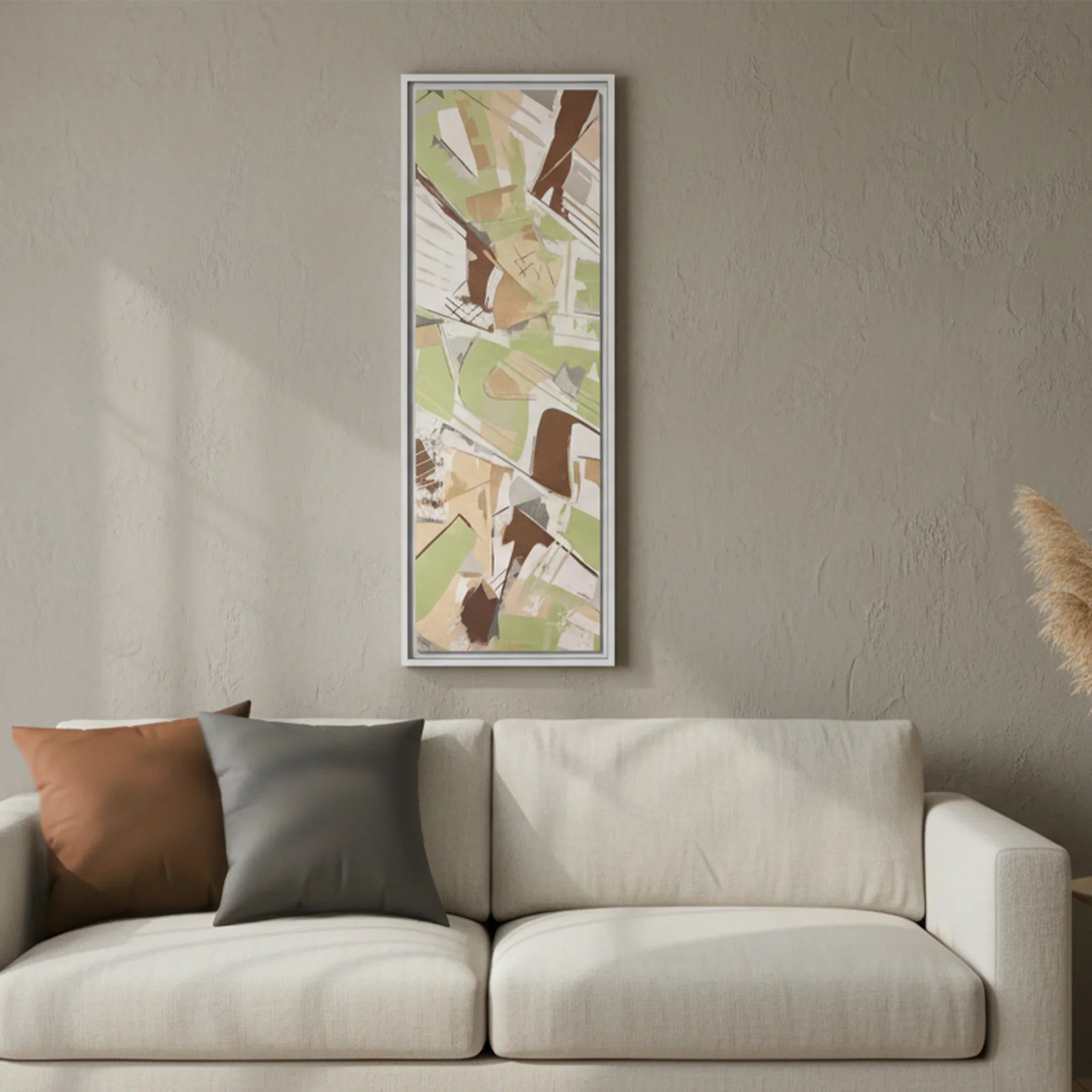 White framed Slim Sage abstract canvas art above cream linen sofa, Saddle Brown and Atomic Grey faux suede pillows, minimalist living room lifestyle.