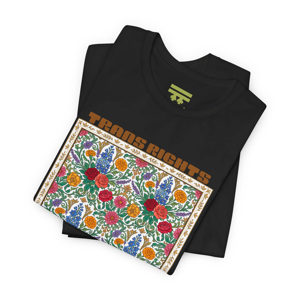 Black T-shirt shown folded at an angle, with the floral front graphic and Trans Rights Are Human Rights text visible.