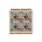 A die-cut magnet featuring a colorful floral pattern with the text 'TRANS RIGHTS ARE HUMAN RIGHTS' in brown lettering, shown on a plain white background.