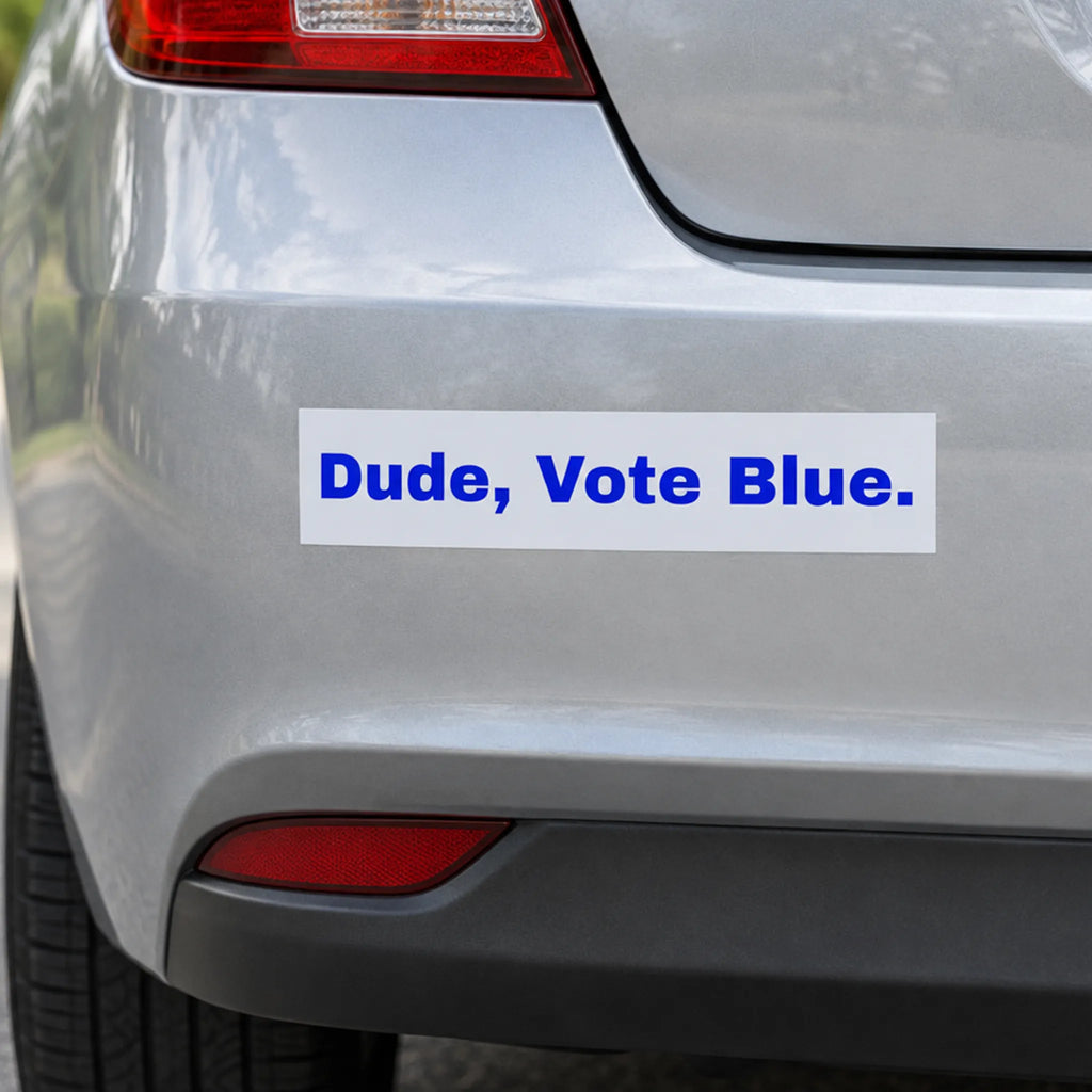 White bumper sticker with bold blue 'Dude, Vote Blue.' lettering on the rear bumper of a silver car.