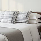 Watercolor gray plaid faux suede throw pillow styled in a calm nordic bedroom.