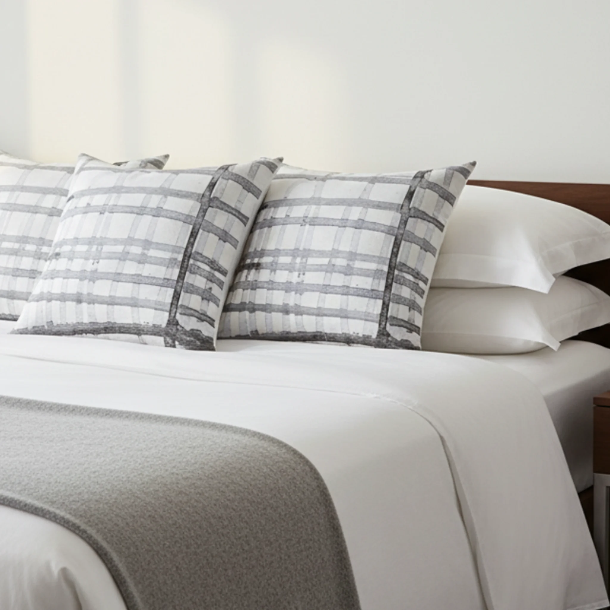 Watercolor gray plaid faux suede throw pillow styled in a calm nordic bedroom.