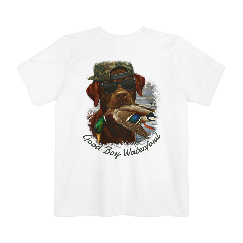 A white t-shirt featuring the Good Boy Waterfowl graphic of a chocolate Labrador wearing sunglasses and a camo snapback, holding a mallard duck, with a watercolor outdoor scene and 'Good Boy Waterfowl' script below.