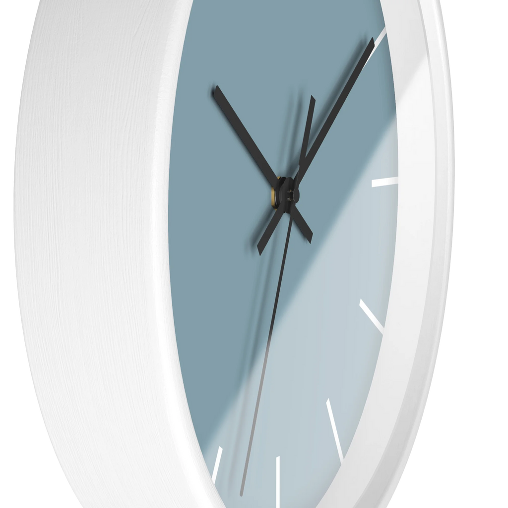 Danish blue minimalist wall clock with white wooden base, black hands, and white markers, side view.