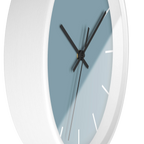 Danish blue minimalist wall clock with white wooden base, black hands, and white markers, side view.