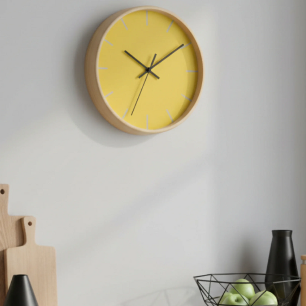 The champ yellow silent wall clock, wooden base, black hands, light grey markers, styled on a kitchen wall, 10 inch, front view.