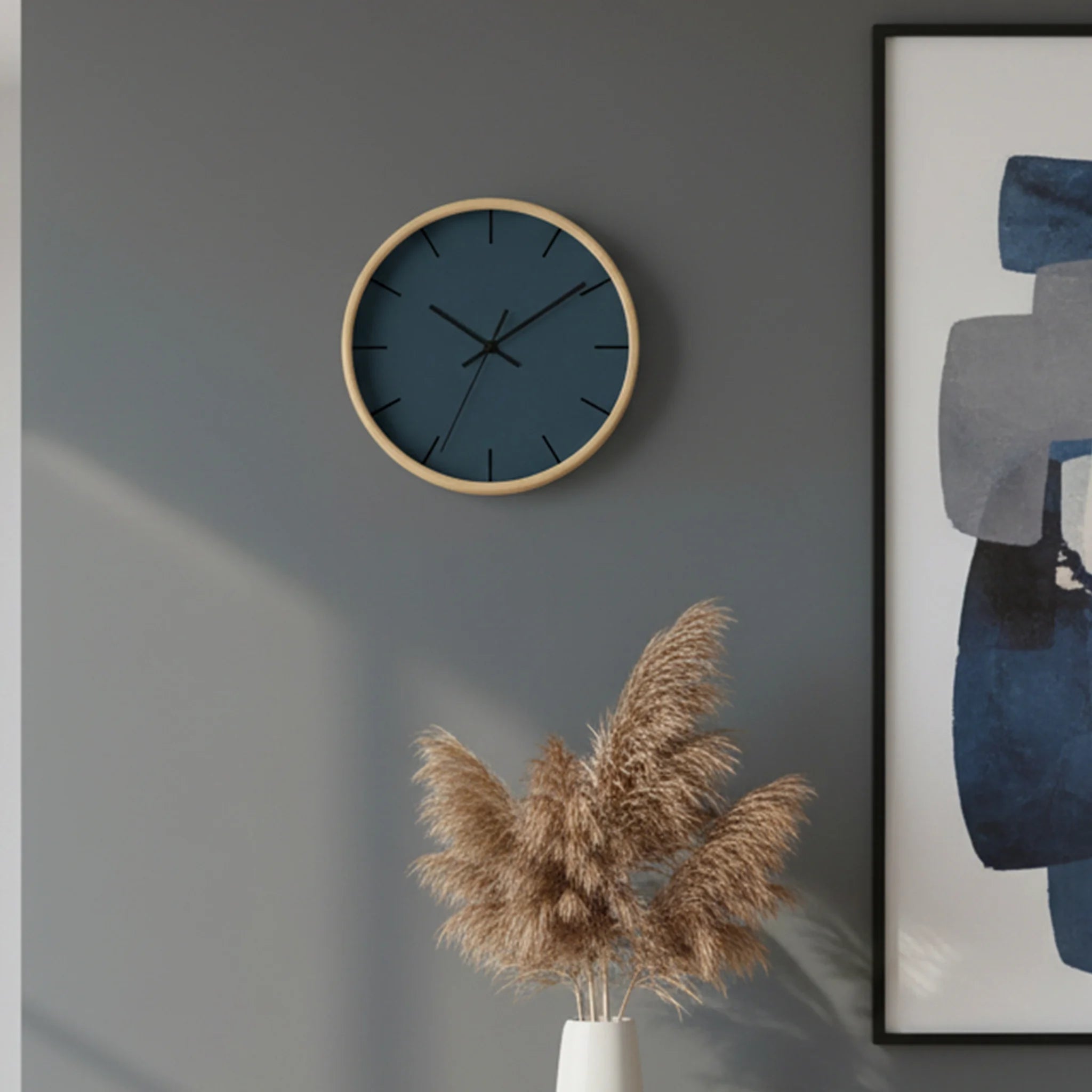 The navy blue slate silent wall clock, wooden base, black hands, black markers, 10 inch, styled on a living room wall, front view.
