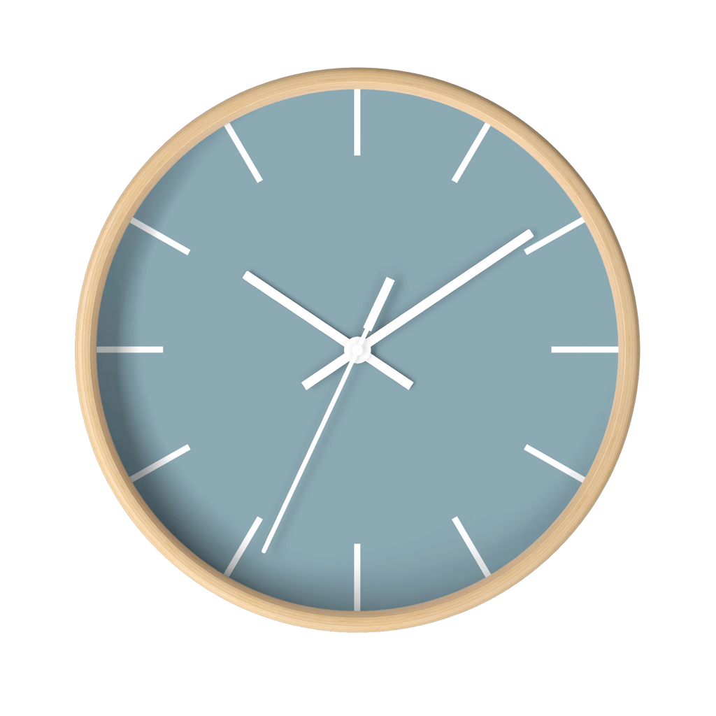 Danish blue minimalist wall clock with natural wooden base, white hands, and white markers, front view.