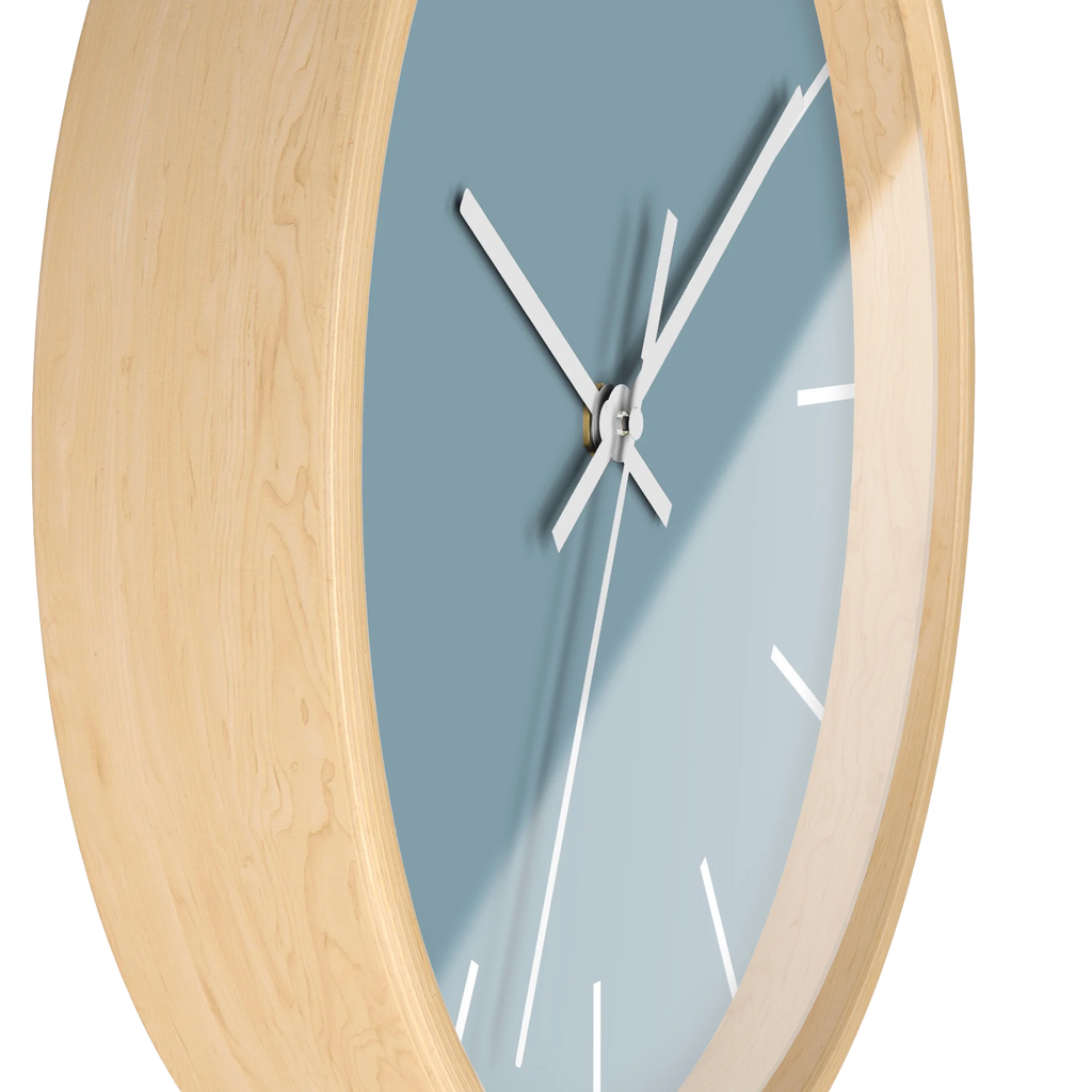 Danish blue minimalist wall clock with natural wooden base, white hands, and white markers, side view.